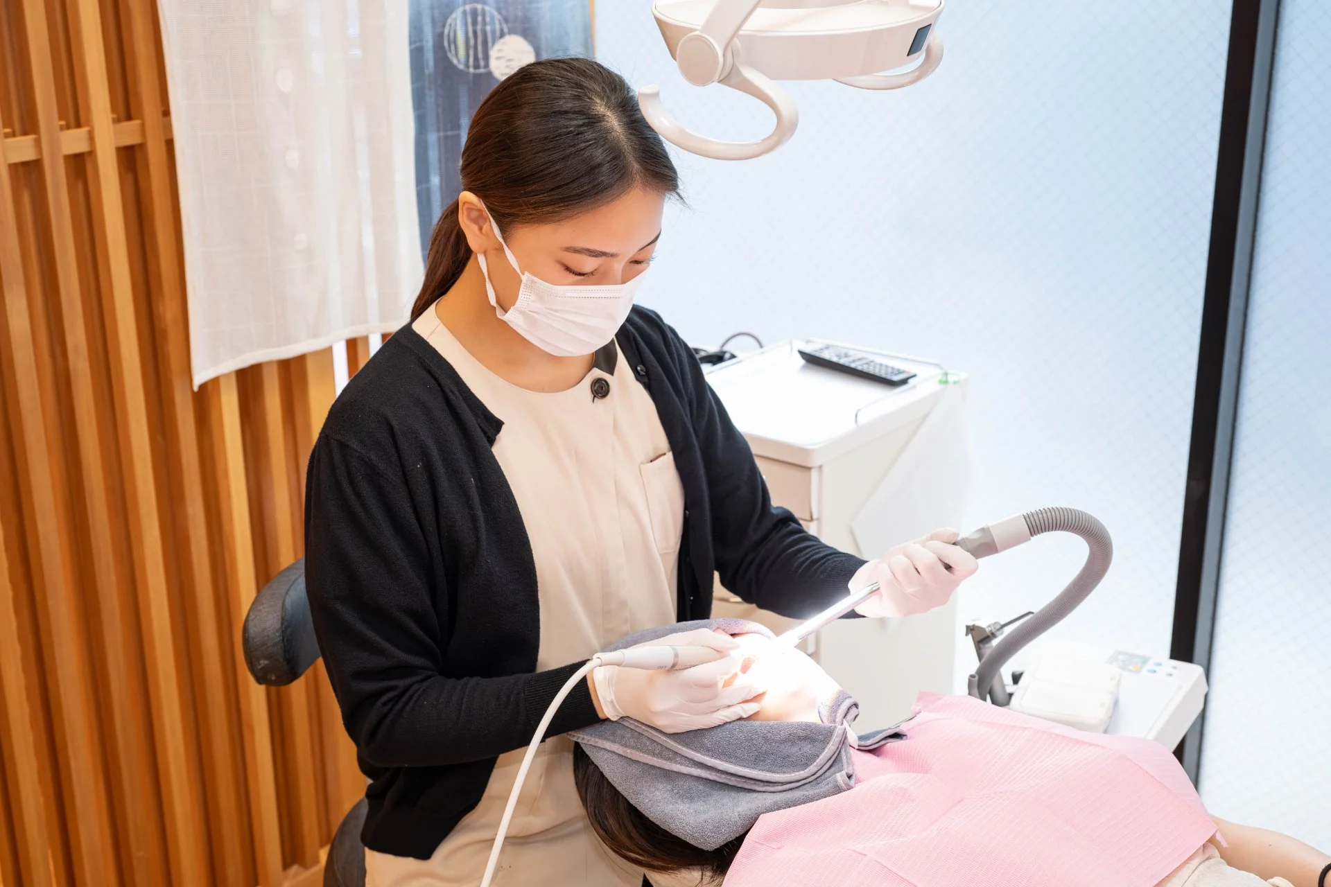 歯科用の口腔内スキャナーを持つ手元